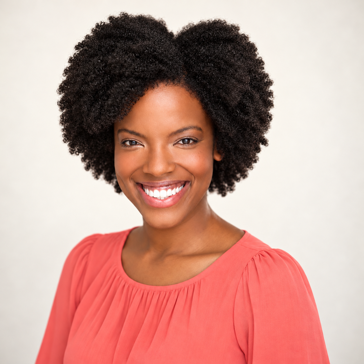 Charla-Maye Cooper, smiling, in a coral top